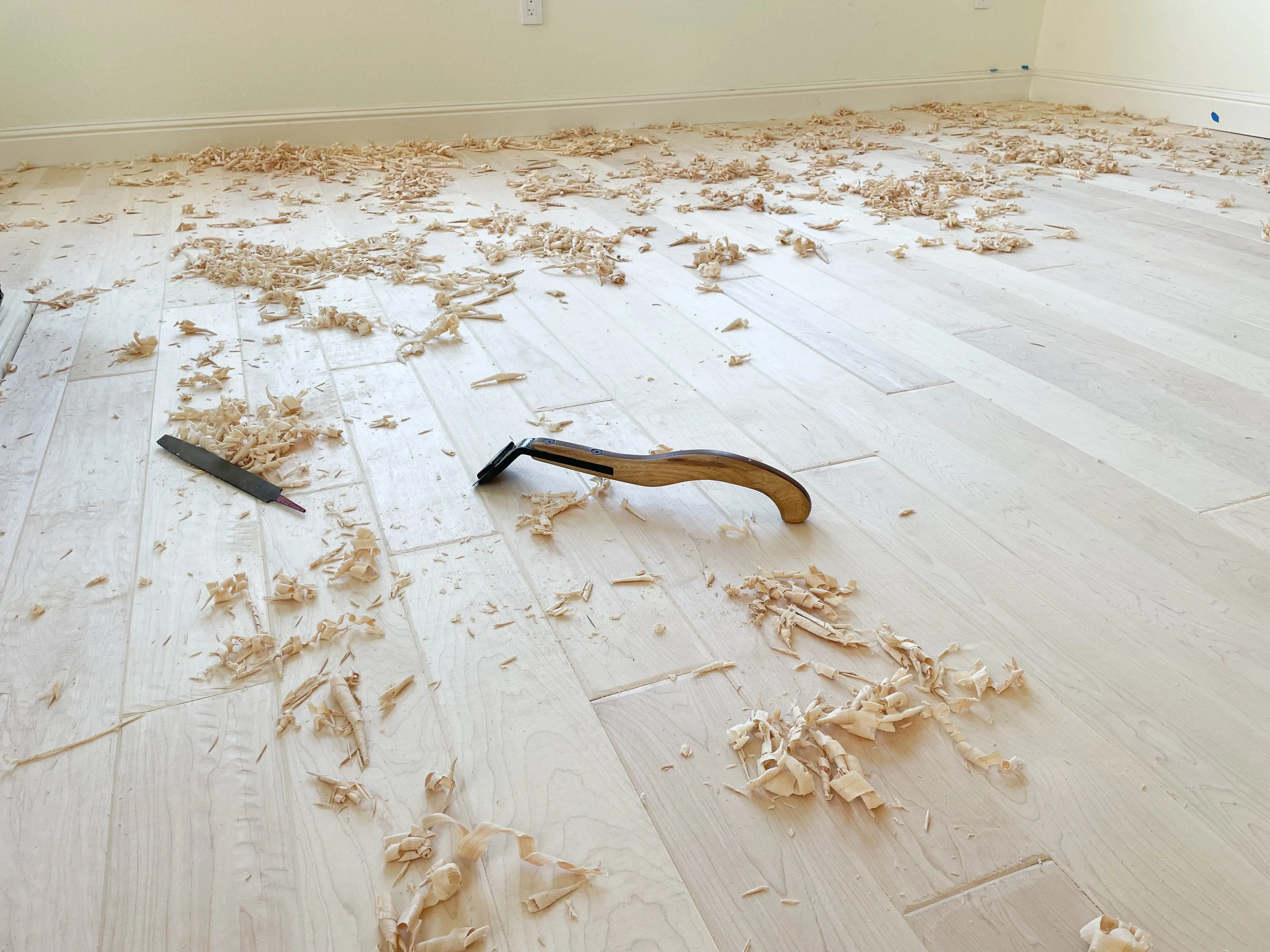 Picture of A look at an engineered unfinished maple floor during the hand scraping process - Alva Flooring Inc.