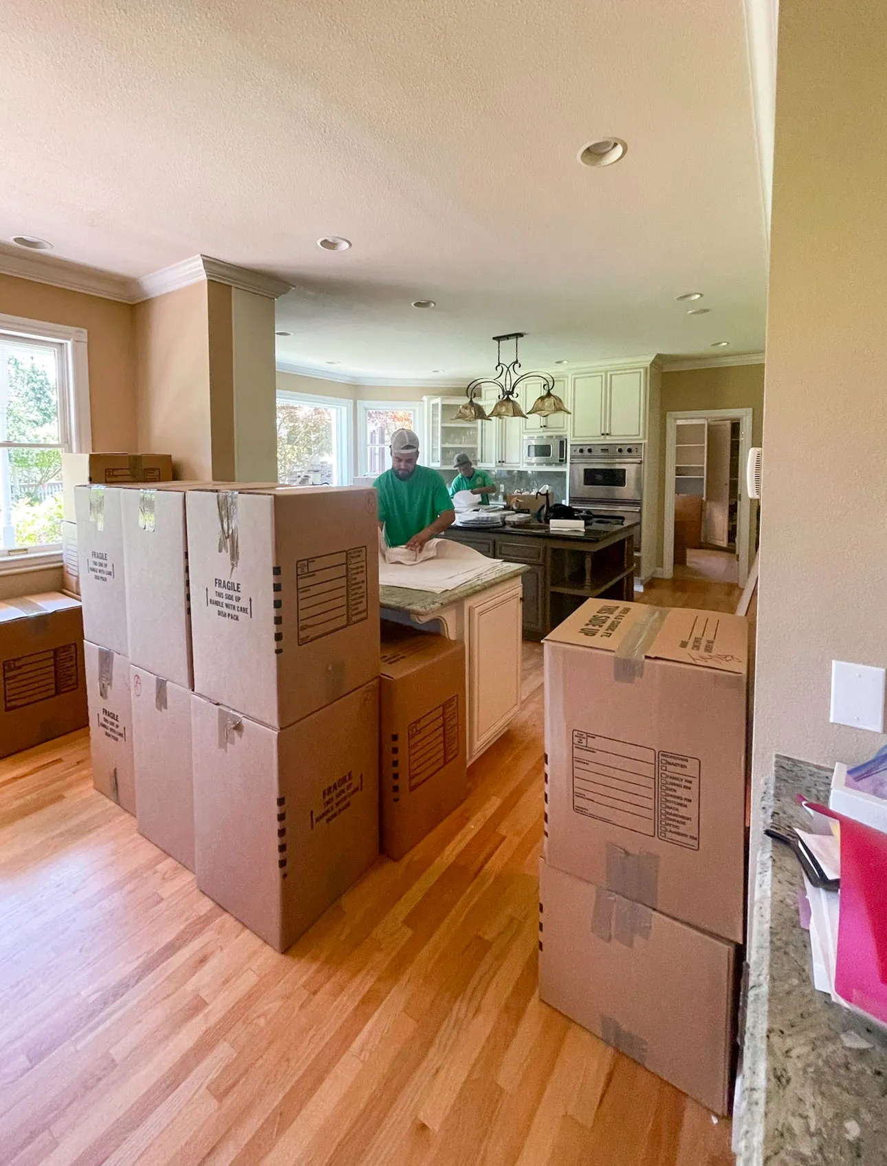 Picture of Two JC Express Movers employees pack up a customer’s kitchen. - JC Express Movers