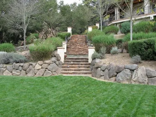 Picture of Jerry Allison Landscaping used natural stone steps and large boulder retaining walls to soften the large elevation changes of th - Jerry Allison Landscaping, Inc.