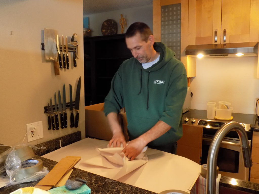 Picture of An A and P Moving employee packs a customer's belongings. - A and P Moving, Inc.