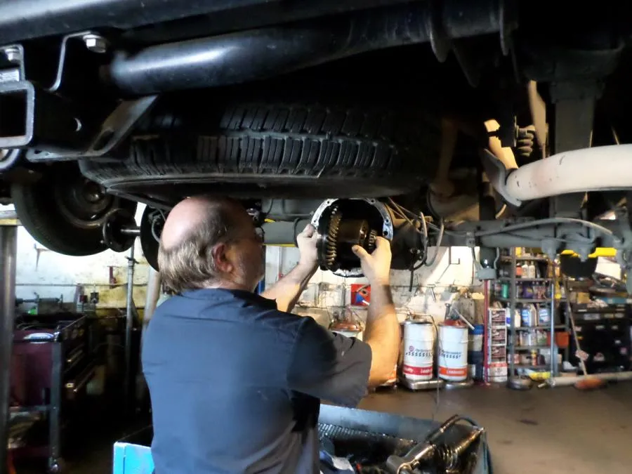 Picture of Owner Chester Kniss works on a customer's car. - Delta Transmission