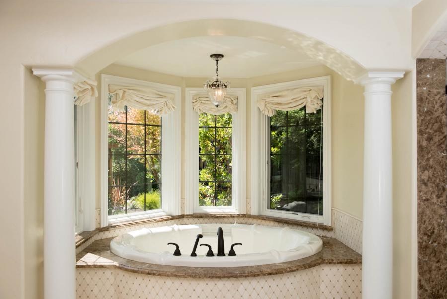 Picture of This bathtub features a marble top and is accented with mosaic marble designs on the face and backsplash. - Derrick Tracey Custom Tile & Marble