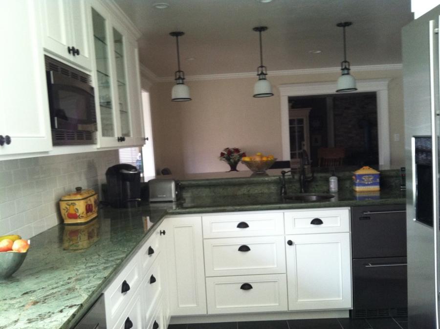 Picture of This kitchen remodel features white costume kitchen cabinets a green granite counter and a copper bar sink. - Devengenzo Landscaping & General Engineering Inc.