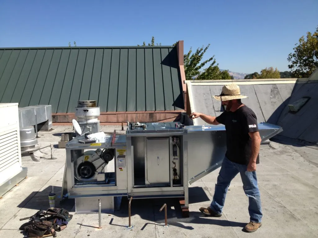 Picture of An Enviro Heating & Air Conditioning technician works on a client's HVAC system. - Enviro Heating & Air Conditioning, Inc.