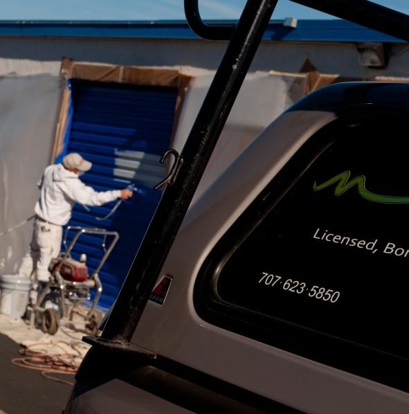 Picture of Owner Mike Chavez paints the door of a commercial storage facility in Rohnert Park. - Mike Chavez Painting