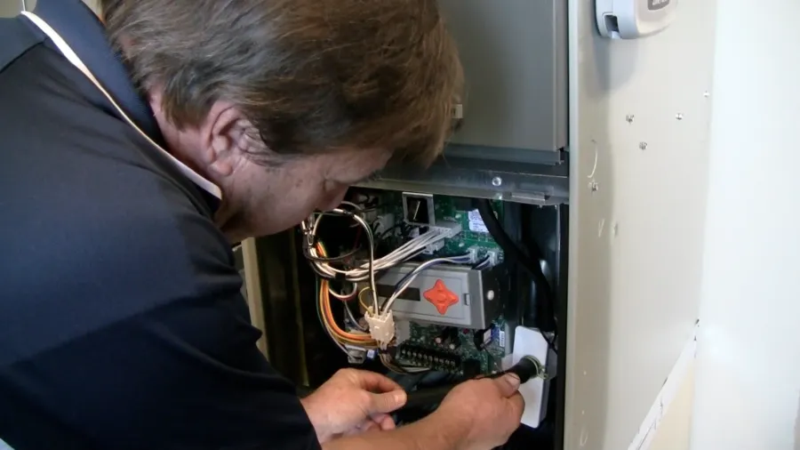 Picture of General Manager Mike Rebholtz works on a customer's HVAC system. - Alternative Heating & Air Conditioning Solutions, Inc.