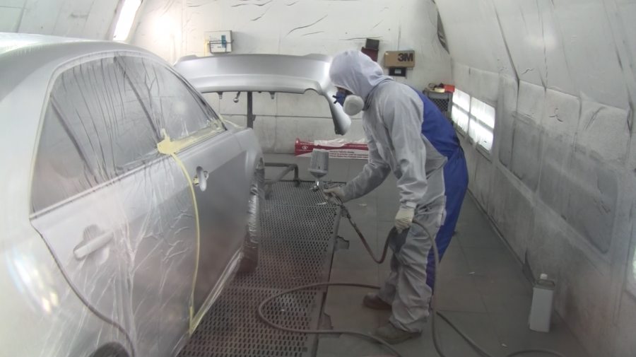 Picture of A Proline Auto Body Services technician applies paint to a customer’s car. - Proline Auto Body Services, Inc.