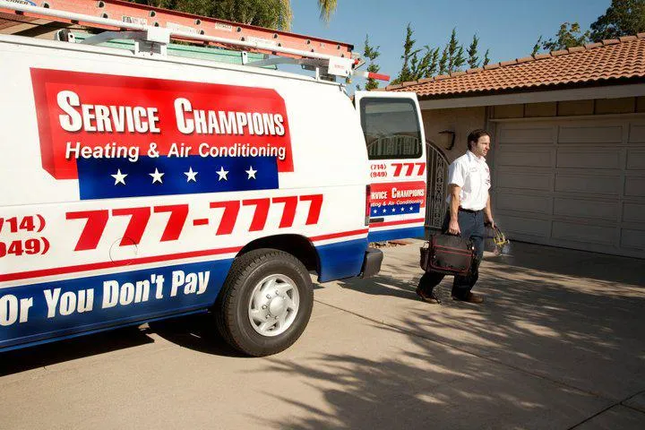 Picture of A Service Champions Plumbing Heating & AC technician prepares to work on a customer's HVAC system. - Service Champions Plumbing, Heating & AC