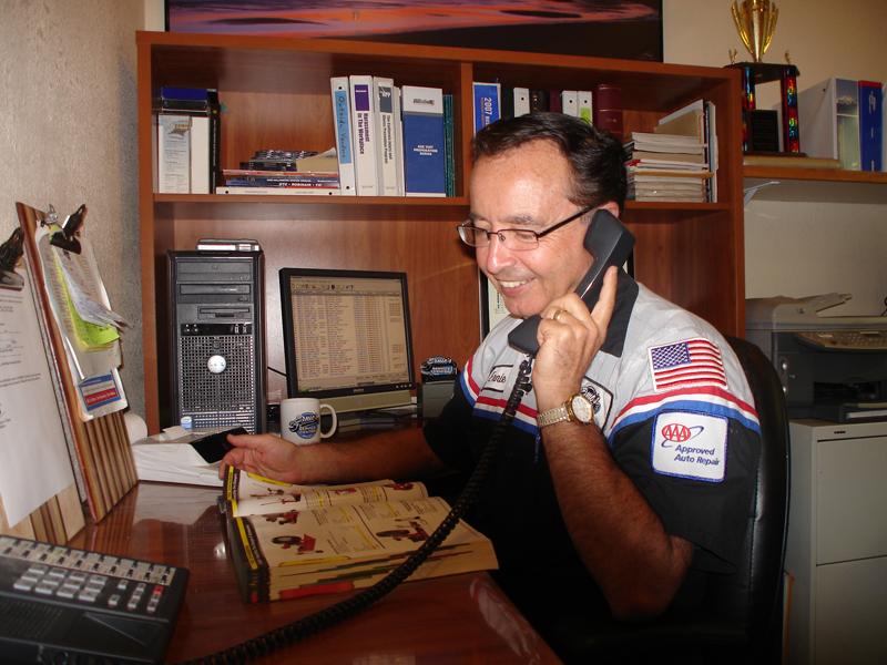 Picture of Owner Ernie Devonshire talks to a customer on the phone. - Ernie's Service Center