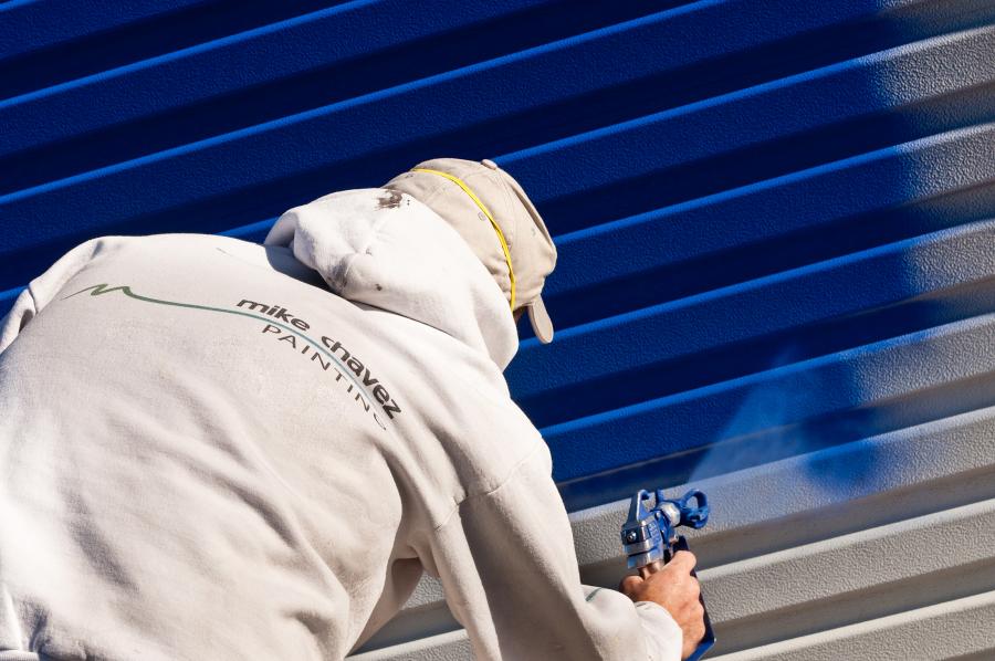 Picture of A Mike Chavez Painting technician spray paints a storage container door for a customer. - Mike Chavez Painting