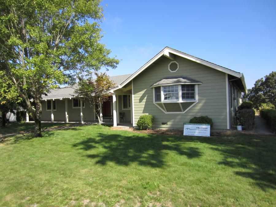 Picture of This country home features green exterior paint and a cream trim. - Mike Chavez Painting