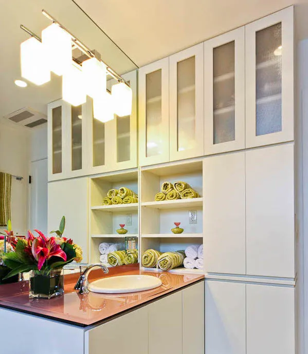 Picture of This customized bathroom is notable for its built-in storage cabinets dramatic LED lighting and bright orange countertop–a 3/4-inch piece of glass with the color sprayed on the bottom. - Roberts Electric Company, Inc.