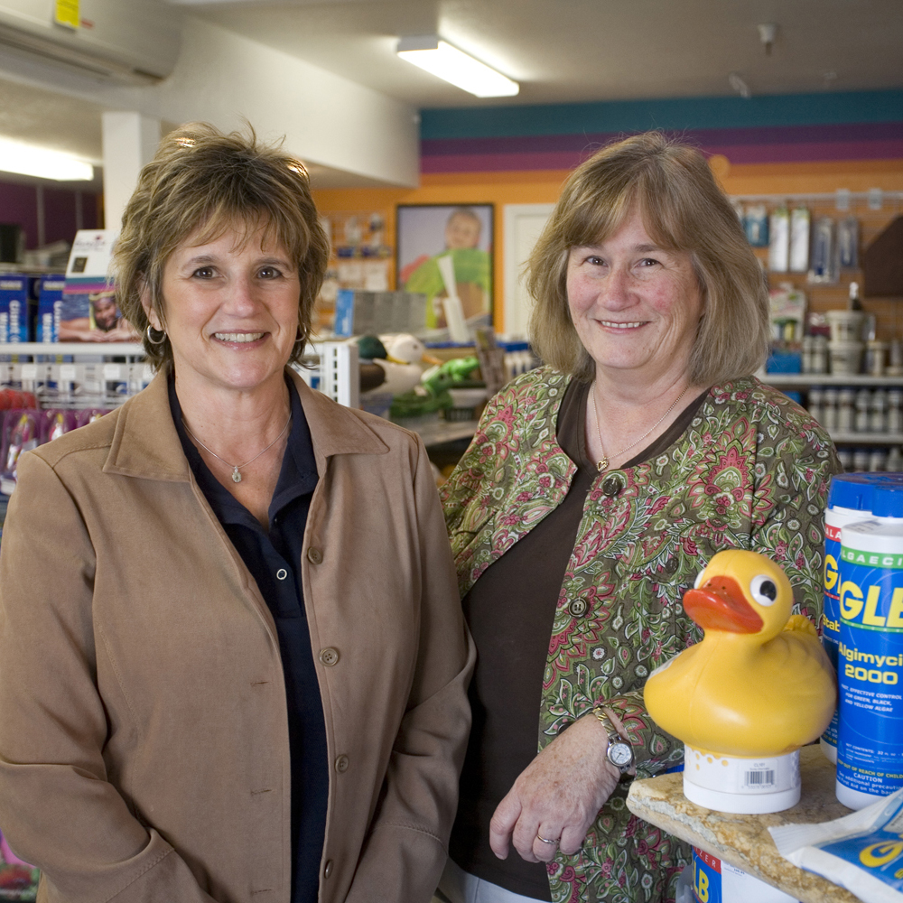 Picture of Owners Kathy Thompson (L) and Sandy Scott pose inside one of Herb’sPool Service’s retail stores. - Herb's Pool Service, Inc.