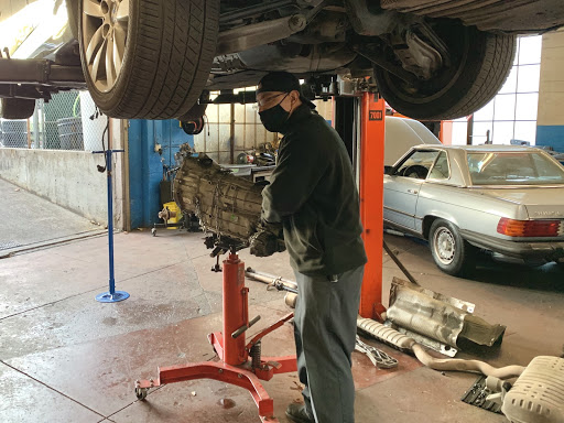 Picture of An Orinda Motors technician stands with a transmission that was just pulled out of a customer’s vehicle. - Orinda Motors, Inc.