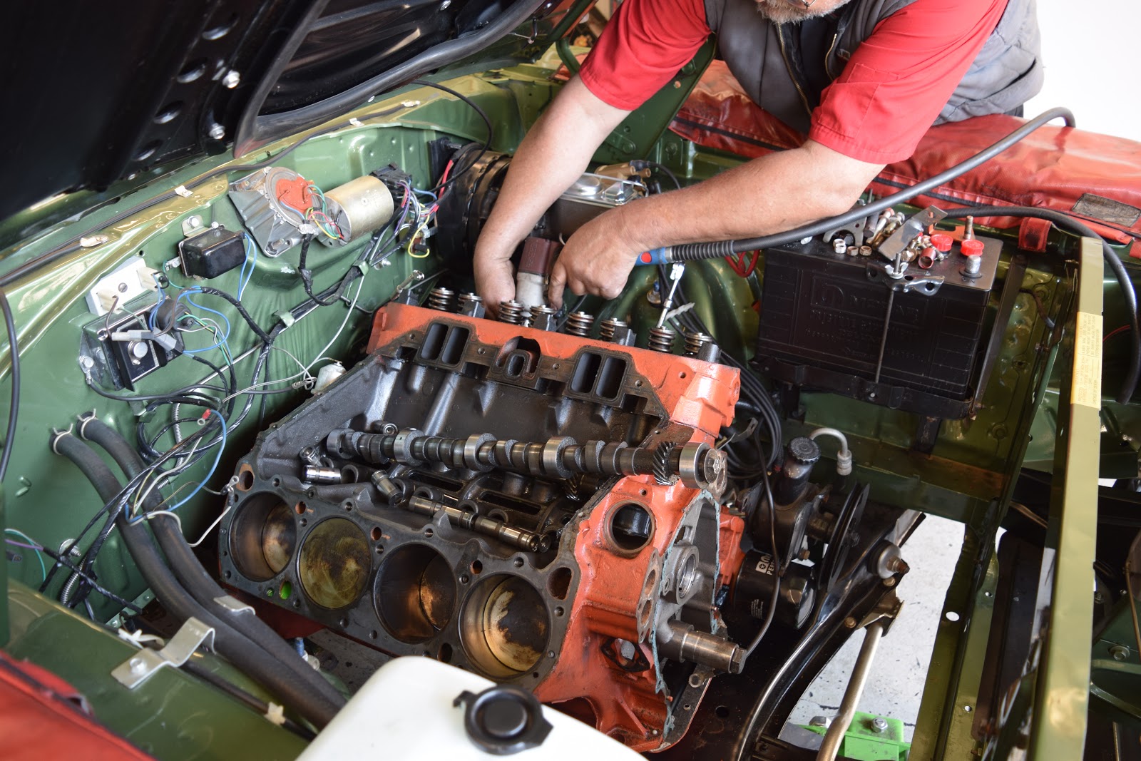 Picture of An Orinda Motors technician works on an engine. - Orinda Motors, Inc.