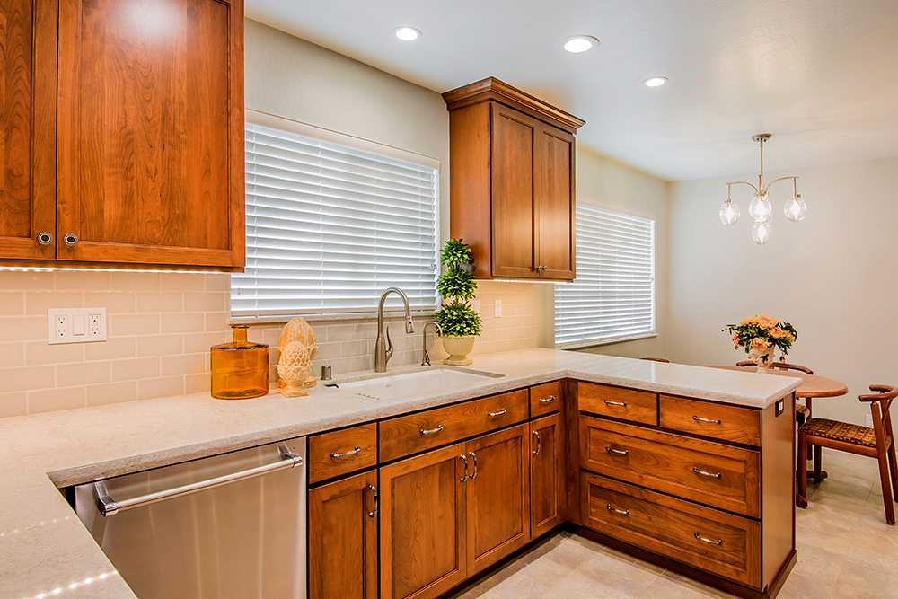 Picture of The cherry cabinetry pops against the light-colored quartz countertop and subway tile backsplash. The sink is a deep cast iron undermount from Kohler and the Franke faucet is in satin nickel. - Cook's Kitchen & Bath, Inc.