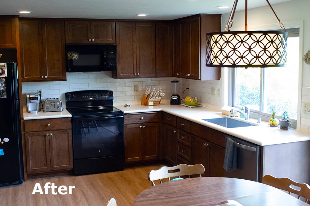 Picture of This walnut cabinetry from Custom Wood Products has a rich hazelnut stain color. The Caesarstone countertop is a lovely contrast along with the dramatic 3-inch by 12-inch subway-style backsplash from Palisades. The undermount sink is stainless steel from Miseno and the American Standard faucet with a pullout sprayer in brushed nickel adds to the entire look. Cook's Kitchen & Bath also replaced the window over the sink and some sliding glass doors that are just out of picture. - Cook's Kitchen & Bath, Inc.