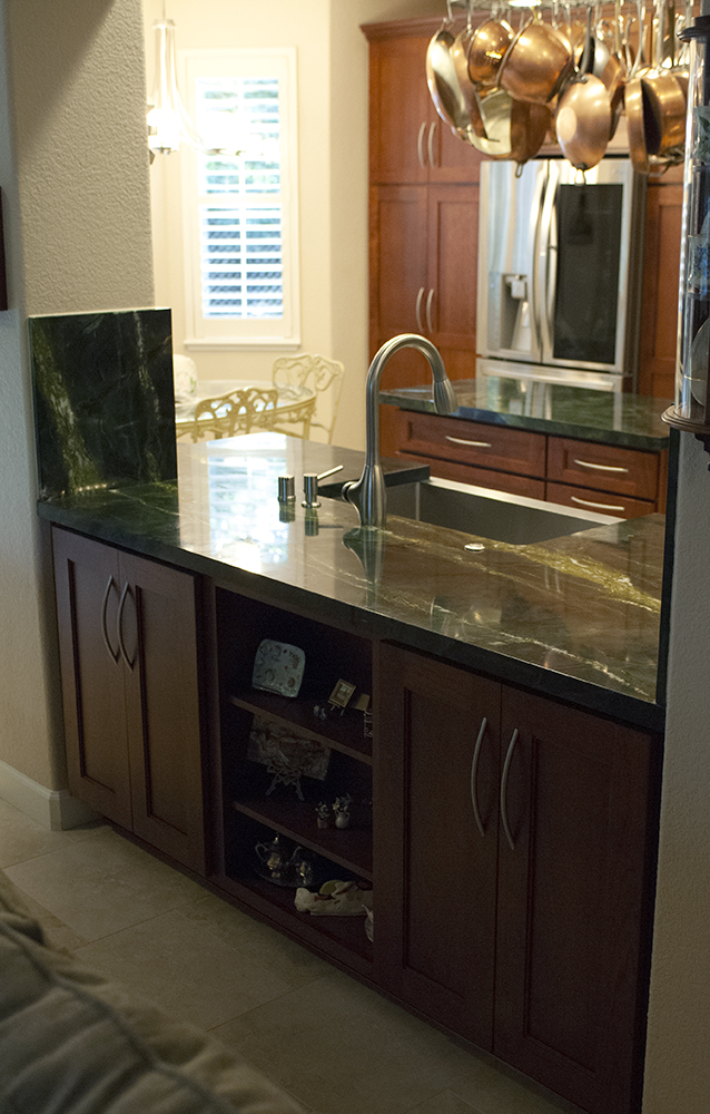 Picture of The passthrough into this family room shows the Total Eclipse Apron sink and stainless pull-down faucet. The breakfast nook can also be seen in the background. - Cook's Kitchen & Bath, Inc.