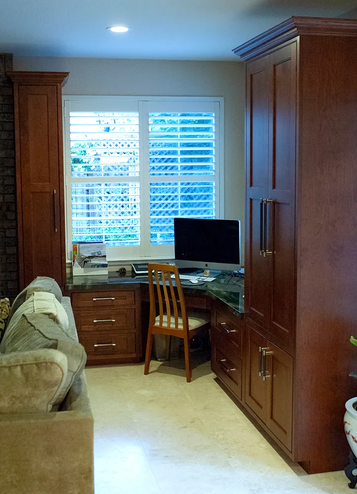 Picture of Cook's Kitchen & Bath placed a new office space at one end of this family room. It features plenty of storage thanks to tall Huntwood cabinets with inset doors and room to work on the matching granite desk. - Cook's Kitchen & Bath, Inc.