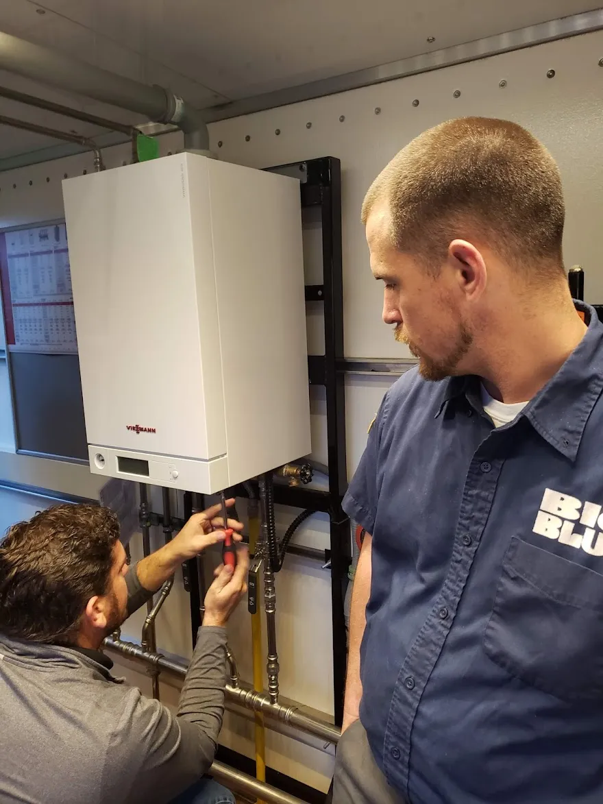 Picture of A Big Blue Plumbing technician receives factory boiler training from a Viessmann representative. - Big Blue Plumbing