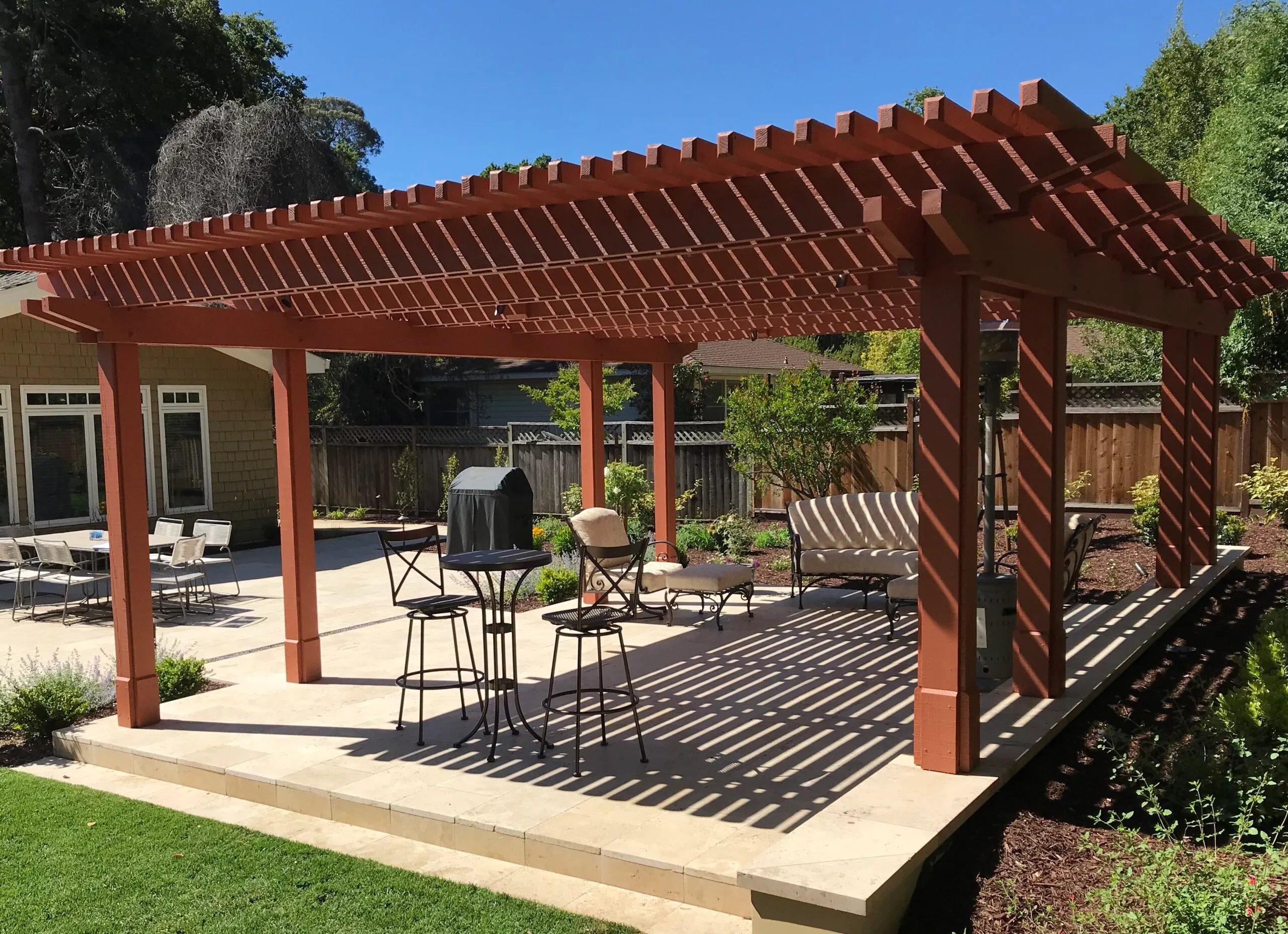 Picture of This custom wood arbor sits atop a travertine patio with a masonry seat wall. - Koch & Associates, Inc.