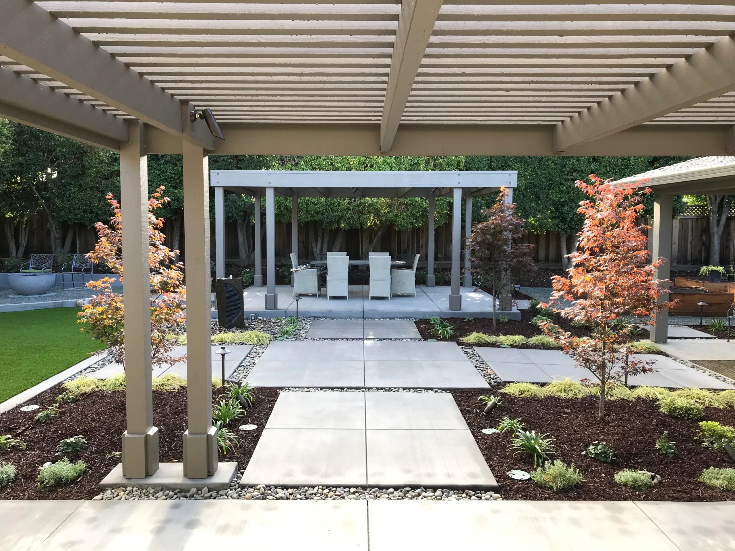 Picture of This backyard remodel features an arbor with an outdoor kitchen a second arbor for dining and a fire pit. - Koch & Associates, Inc.