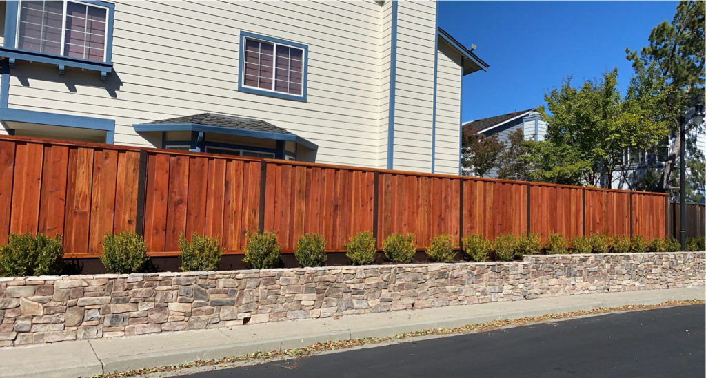 Picture of AMM Fencing used 2x4x16-inch, thick-cut top rails and pressure-treated 2×8 kickboards to create this “board on board” redwood fence. - AMM Fencing