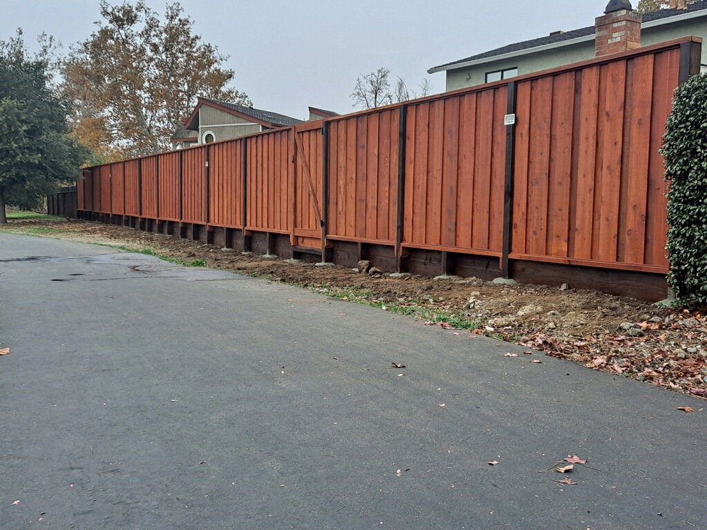 Picture of AMM Fencing installs retaining walls with redwood fences. - AMM Fencing